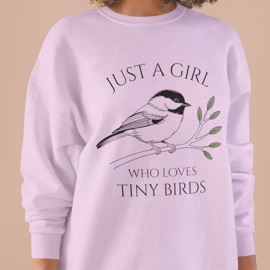 Woman wearing a light purple sweatshirt with a bird graphic 